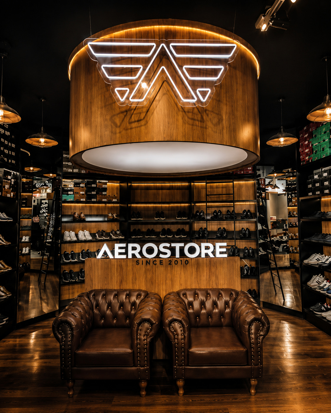 Interior da loja AEROSTORE com iluminação, sofás e vitrine de calçados